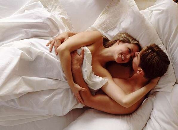 žena v posteli s mužem, který zvětšuje jeho péro