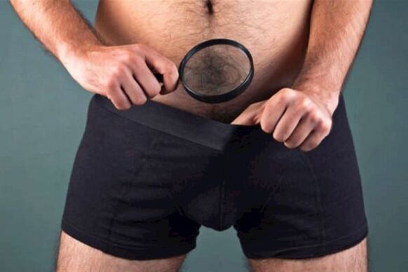muž s lupou zkoumá svůj penis a chce ho zahustit